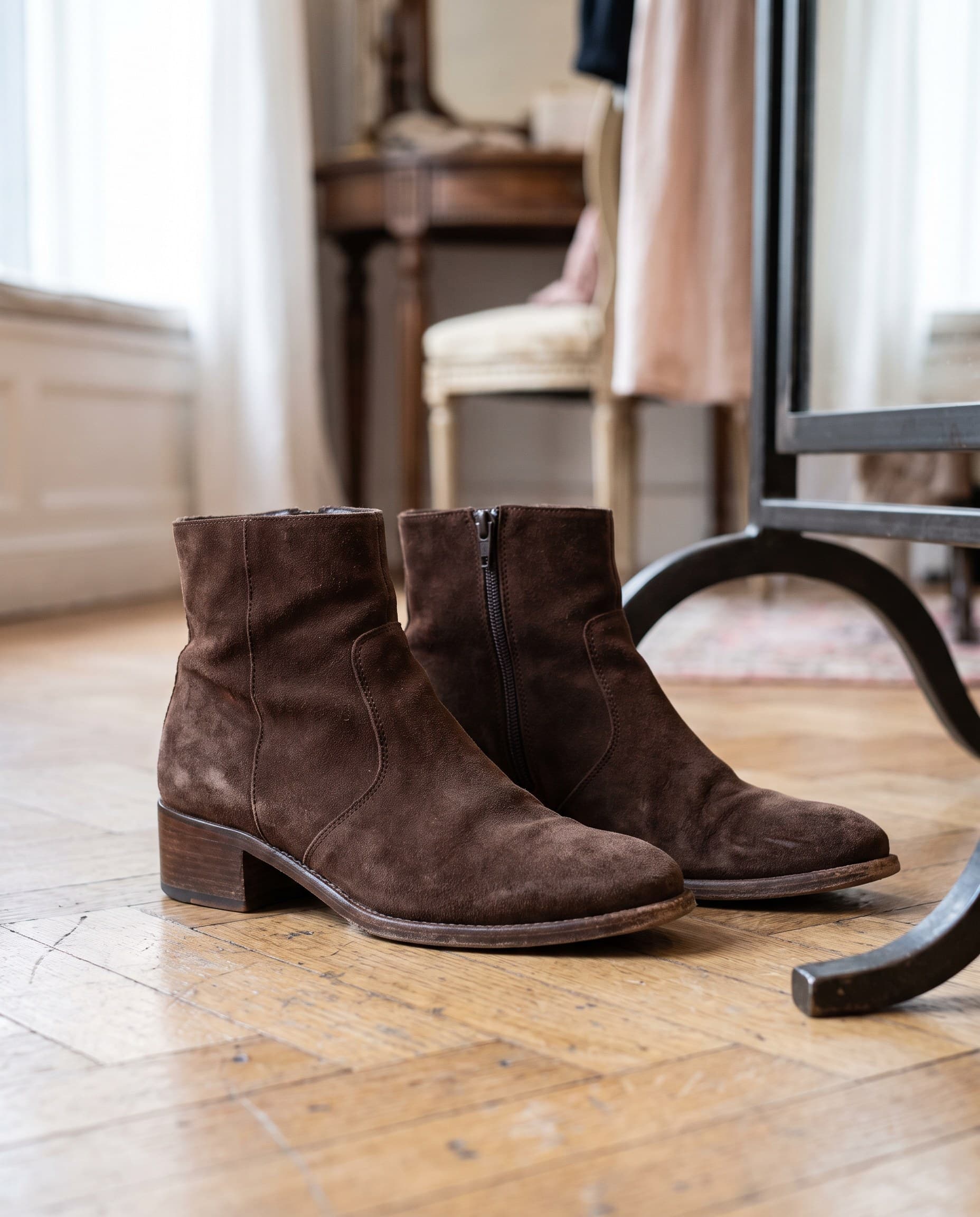 Des bottines en daim chocolat sur le parquet